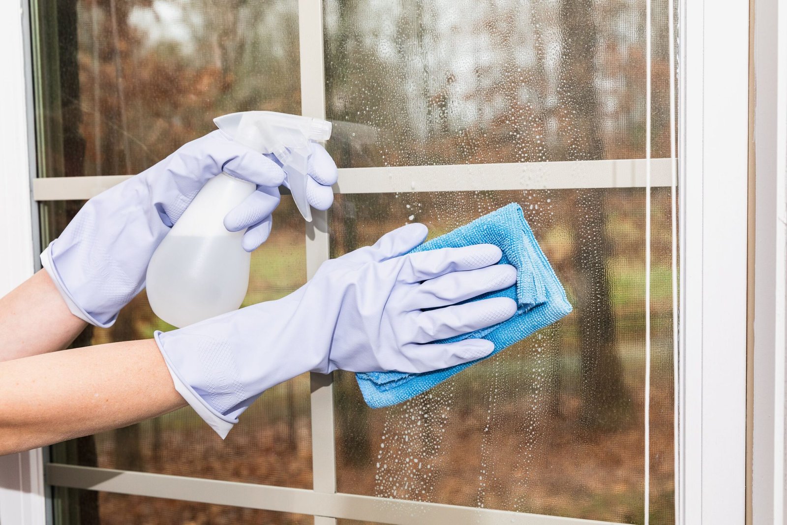 Technician cleaning second-story exterior windows on a Charleston home with spotless results