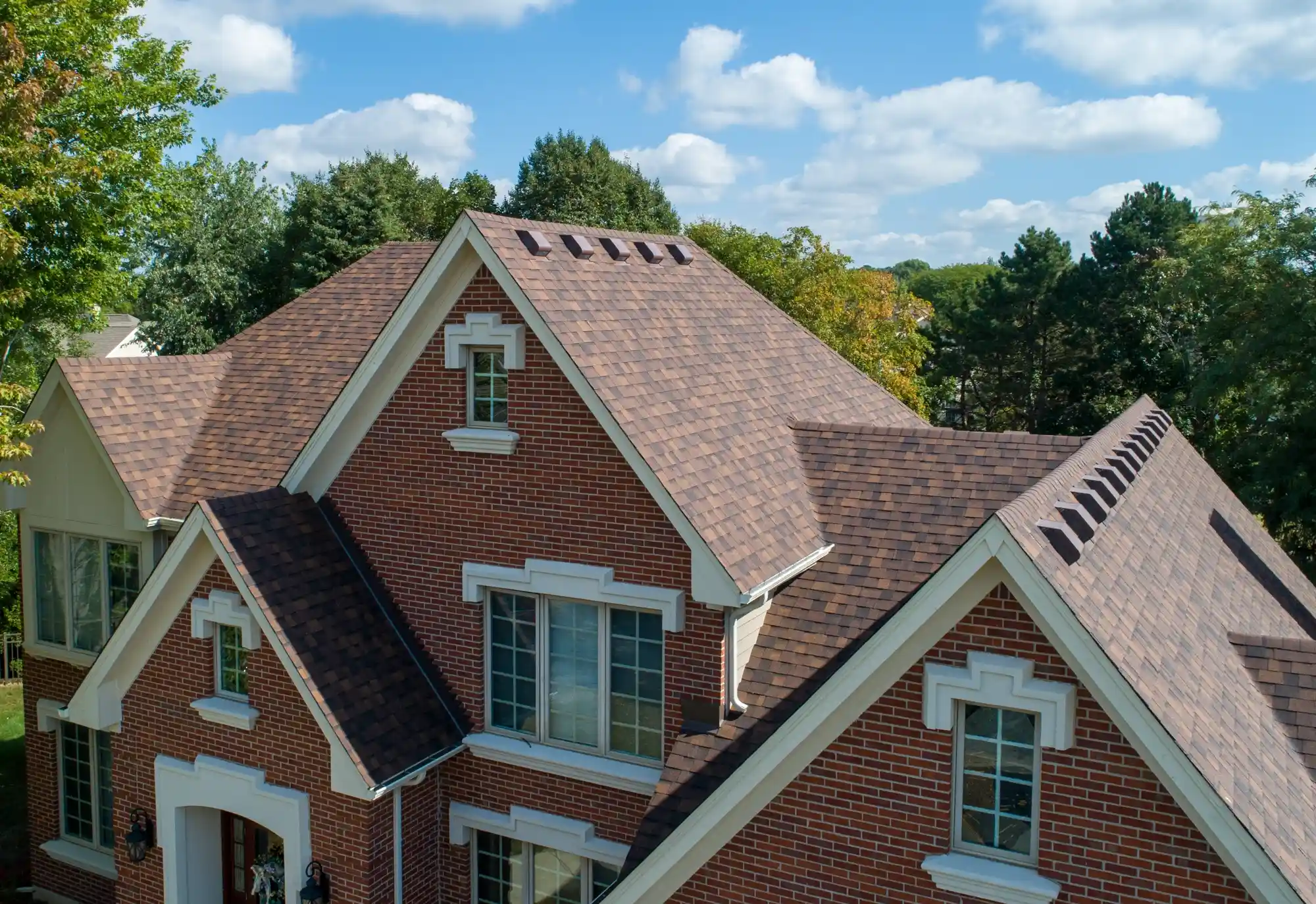 Roofing crew replacing worn shingles on an occupied home in a quiet residential neighborhood