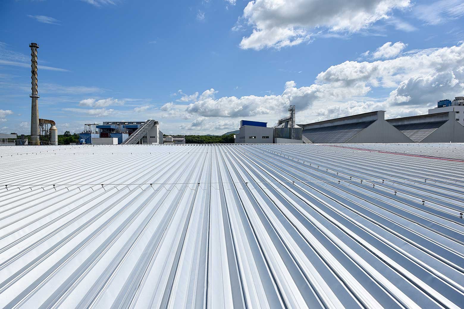 Commercial roofing crew repairing a flat roof above an occupied neighborhood retail plaza