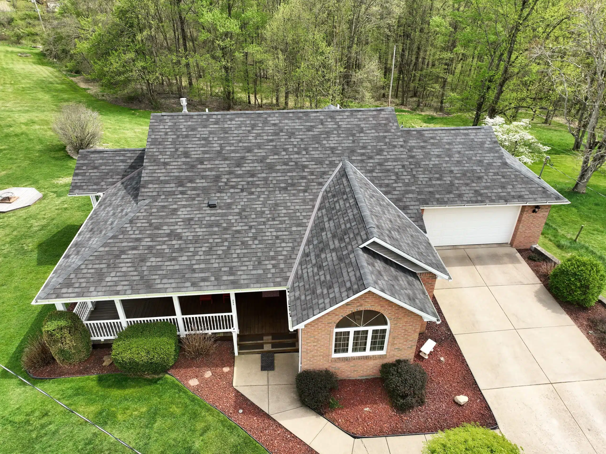 Roofing crew replacing worn shingles on an occupied home in a quiet residential neighborhood