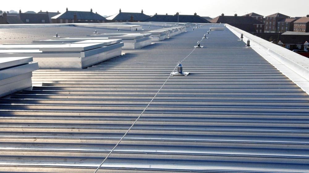 Commercial roofing crew repairing a flat roof above an occupied neighborhood retail plaza